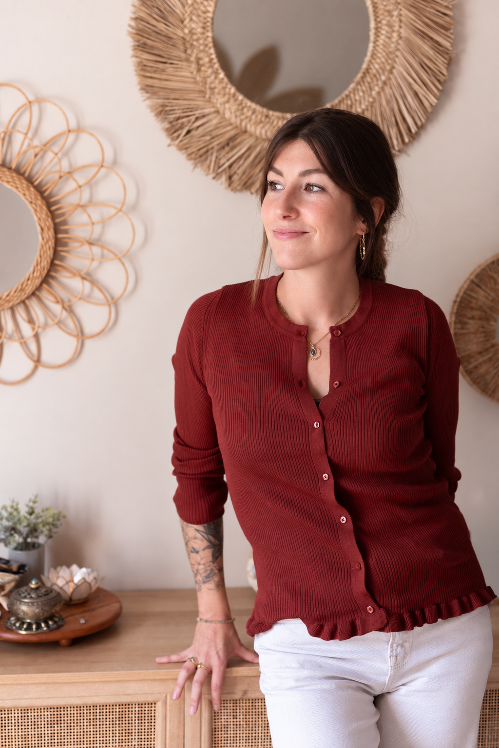 Portrait de Sandra, fondatrice d'Espace Sanora, dans un intérieur chaleureux avec miroirs en rotin